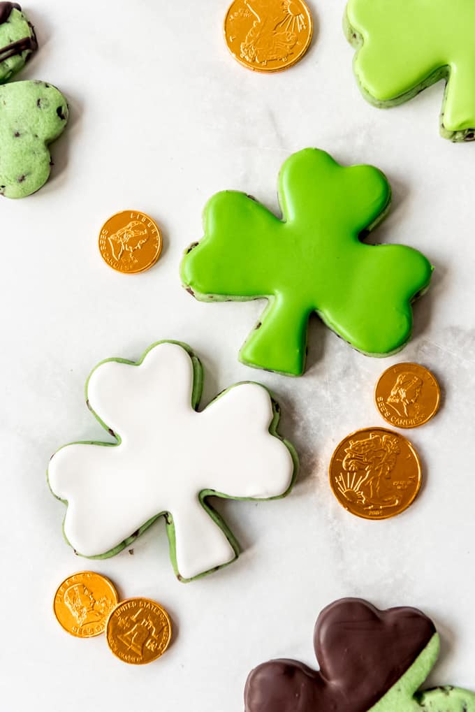 Decorated shamrock cookies next to gold coins.