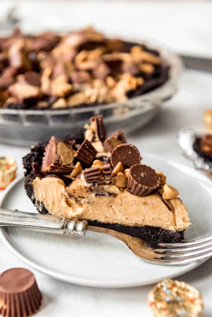 A slice of Peanut Butter Cheesecake on a white plate with a silver fork