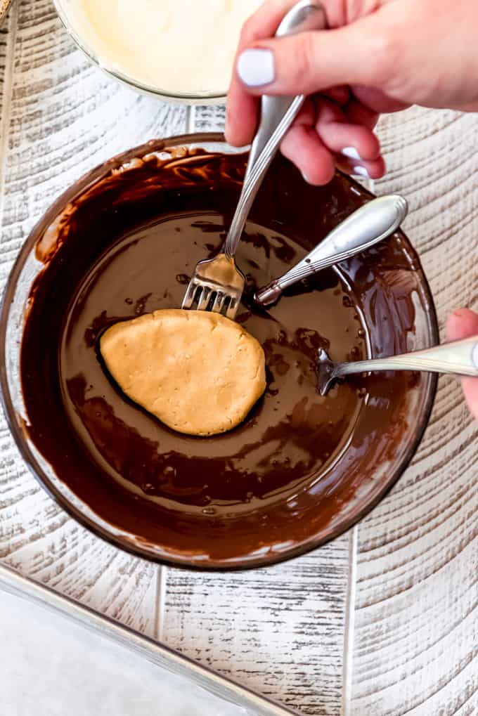 Dipping a peanut butter egg center into melted chocolate.