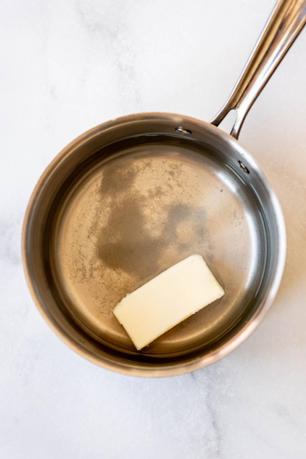 A pan with water, butter, and salt in it.