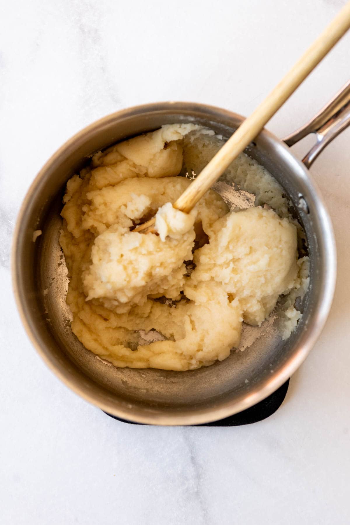 Stirring flour into choux pastry dough.