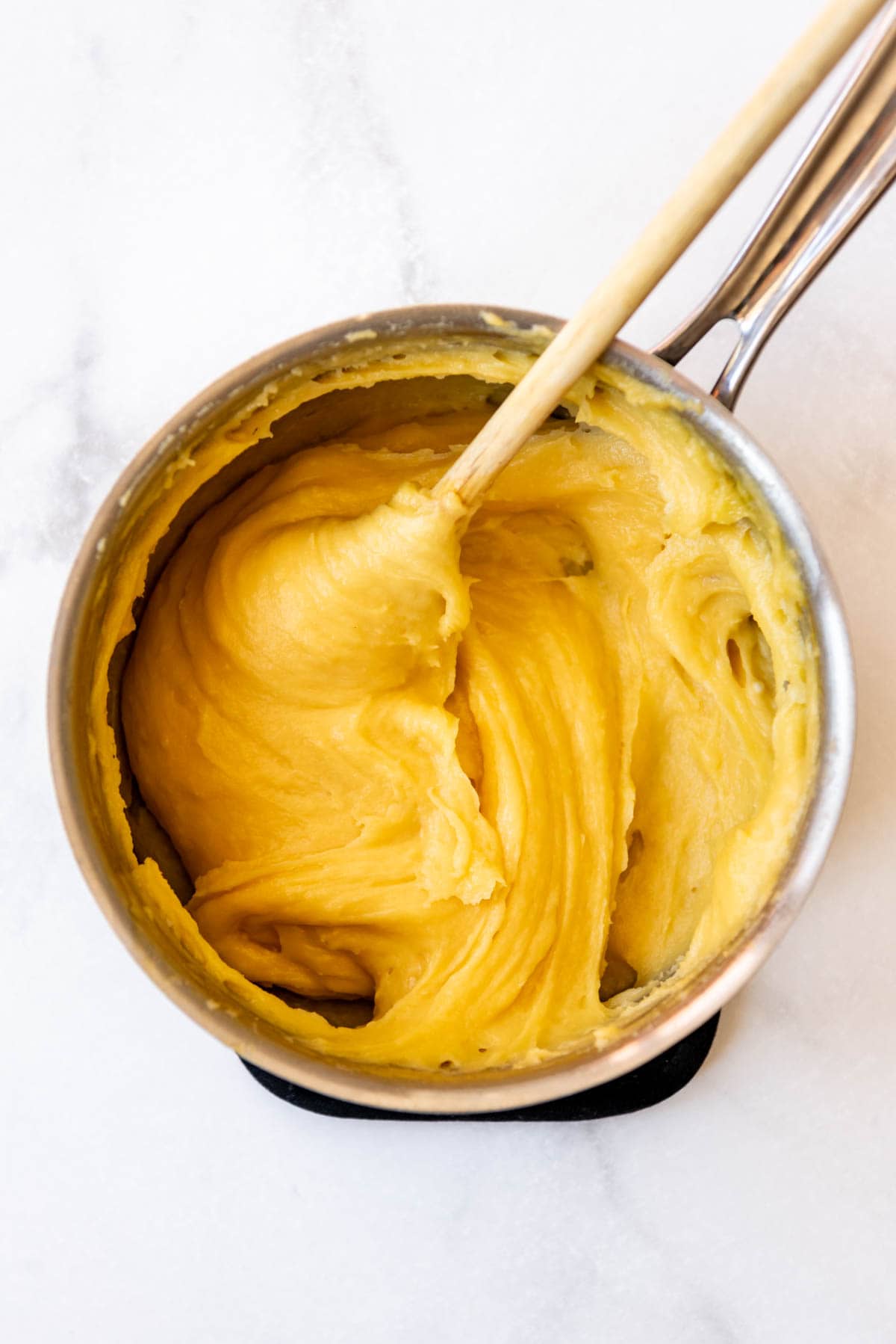 Thick choux pastry in a saucepan.