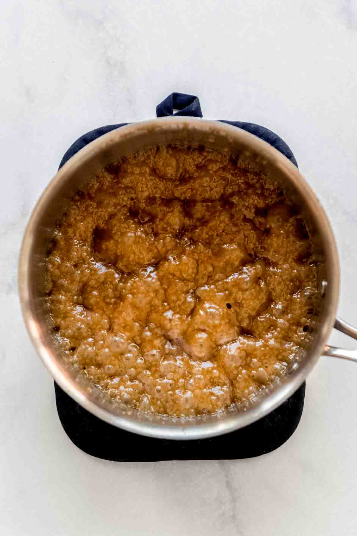 Ingredients have been combined and heated in a saucepan, and a bubbling texture is visible. 