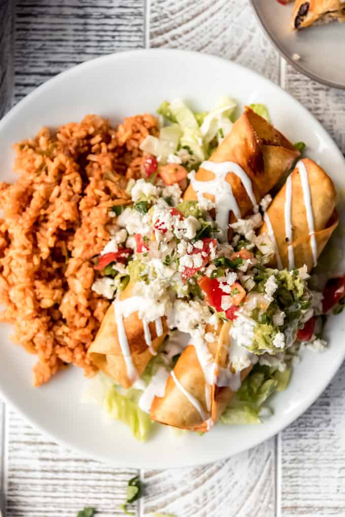 a plate of flautas and Mexican rice