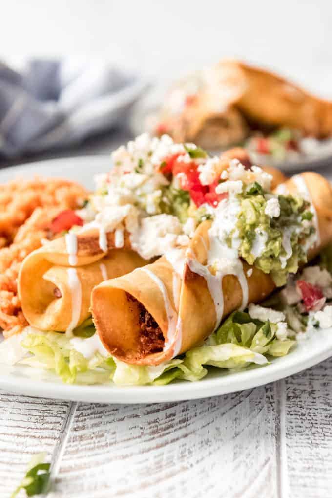 two chicken flautas on a plate