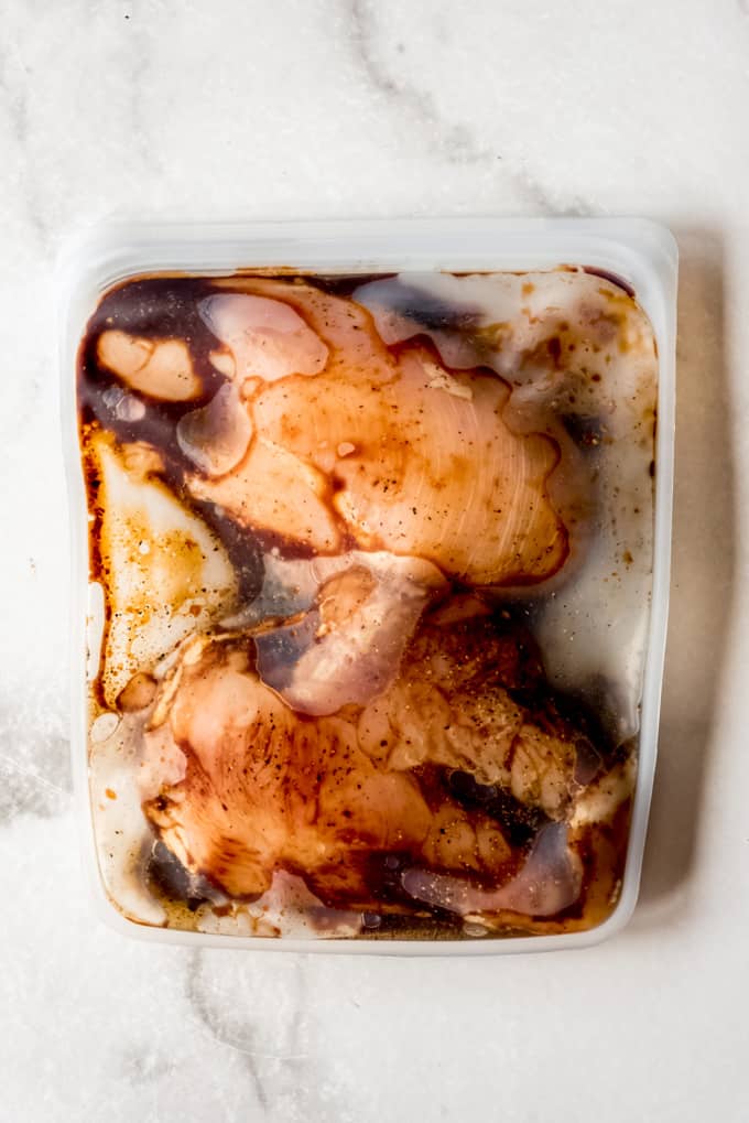 Raw chicken marinating in airtight container