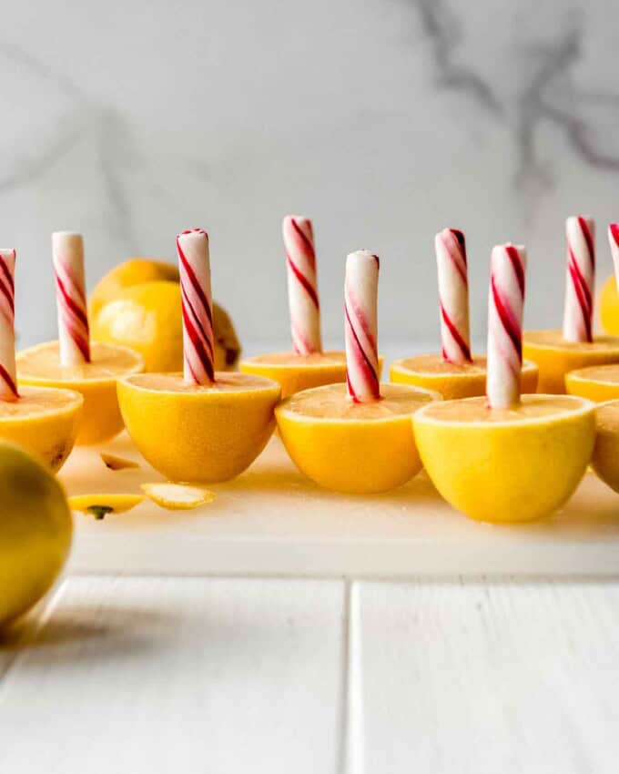 Halved lemons with peppermint sticks stuck in them.