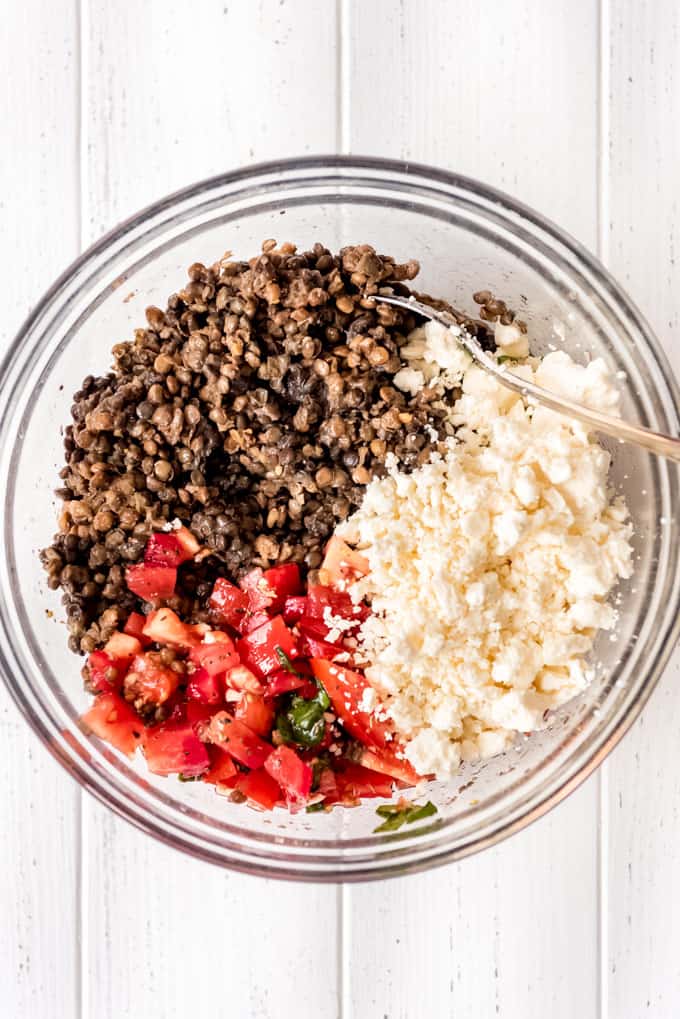 lentils, tomatoes, feta cheese, basil, and olive oil in a bowl