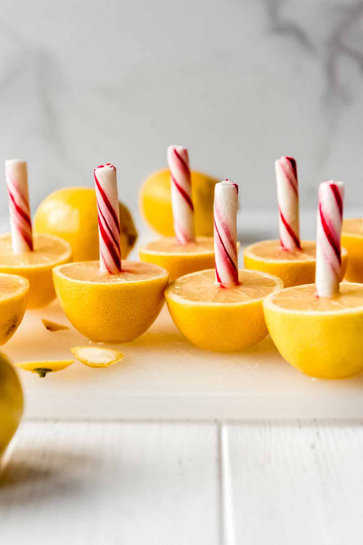 Halved lemons with peppermint sticks stuck in them.