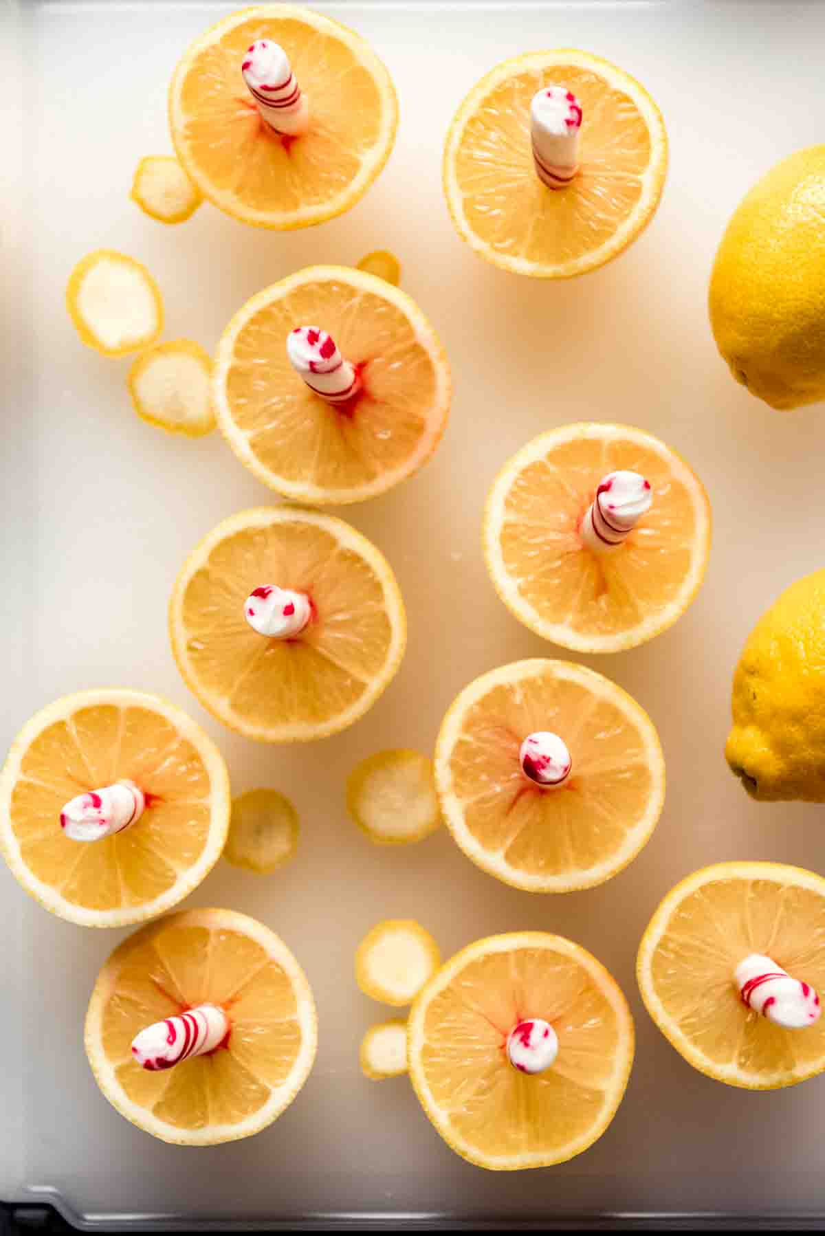 Peppermint sticks stuck into sliced lemon halves.