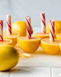 Halved lemons with peppermint sticks stuck in them.