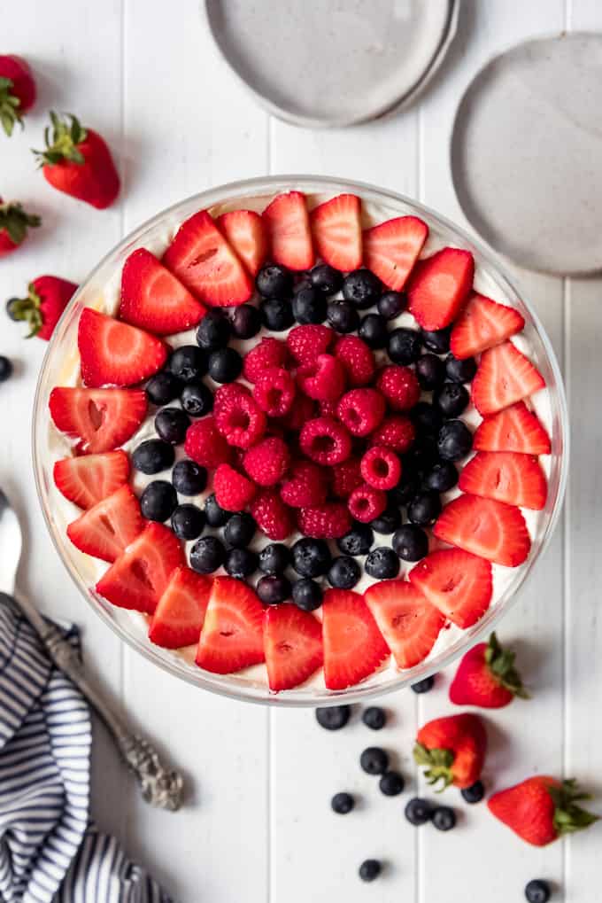 strawberries, blueberries, and raspberries arranged in decorative circles on top of a trifle