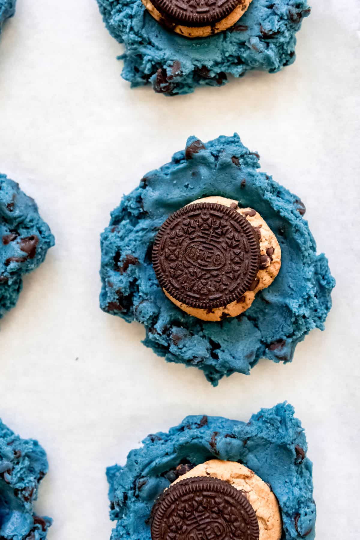 an Oreo and Chips Ahoy cookie on top of blue chocolate chip cookie dough