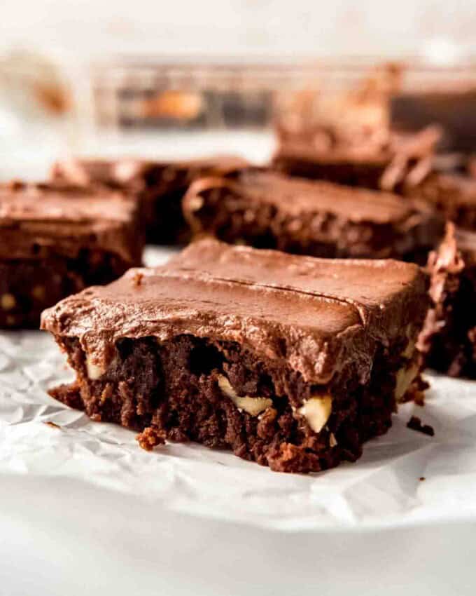 A frosted brownie with walnuts.