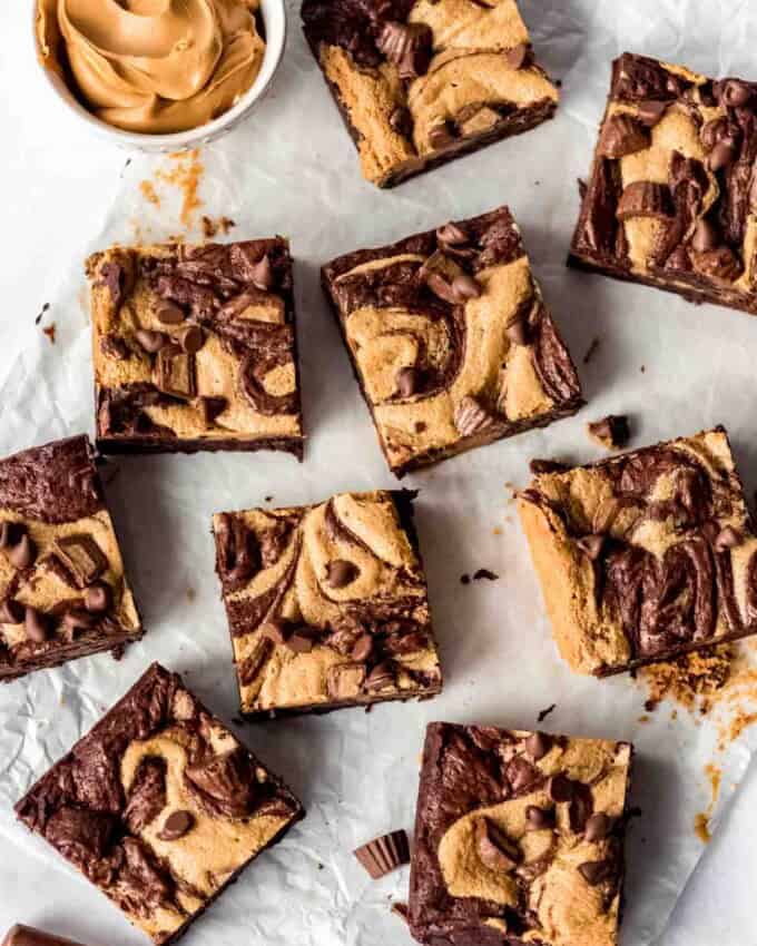 Individual slices of Peanut Butter Swirl Brownies on parchment paper, overhead shot.