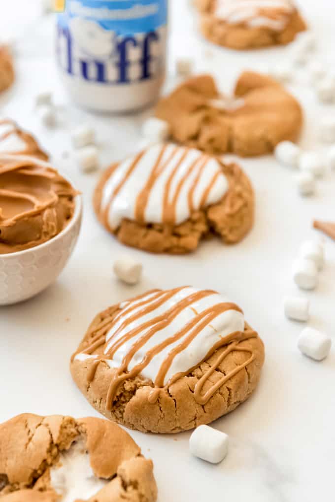 large peanut butter cookies covered in marshmallow fluff and peanut butter drizzle