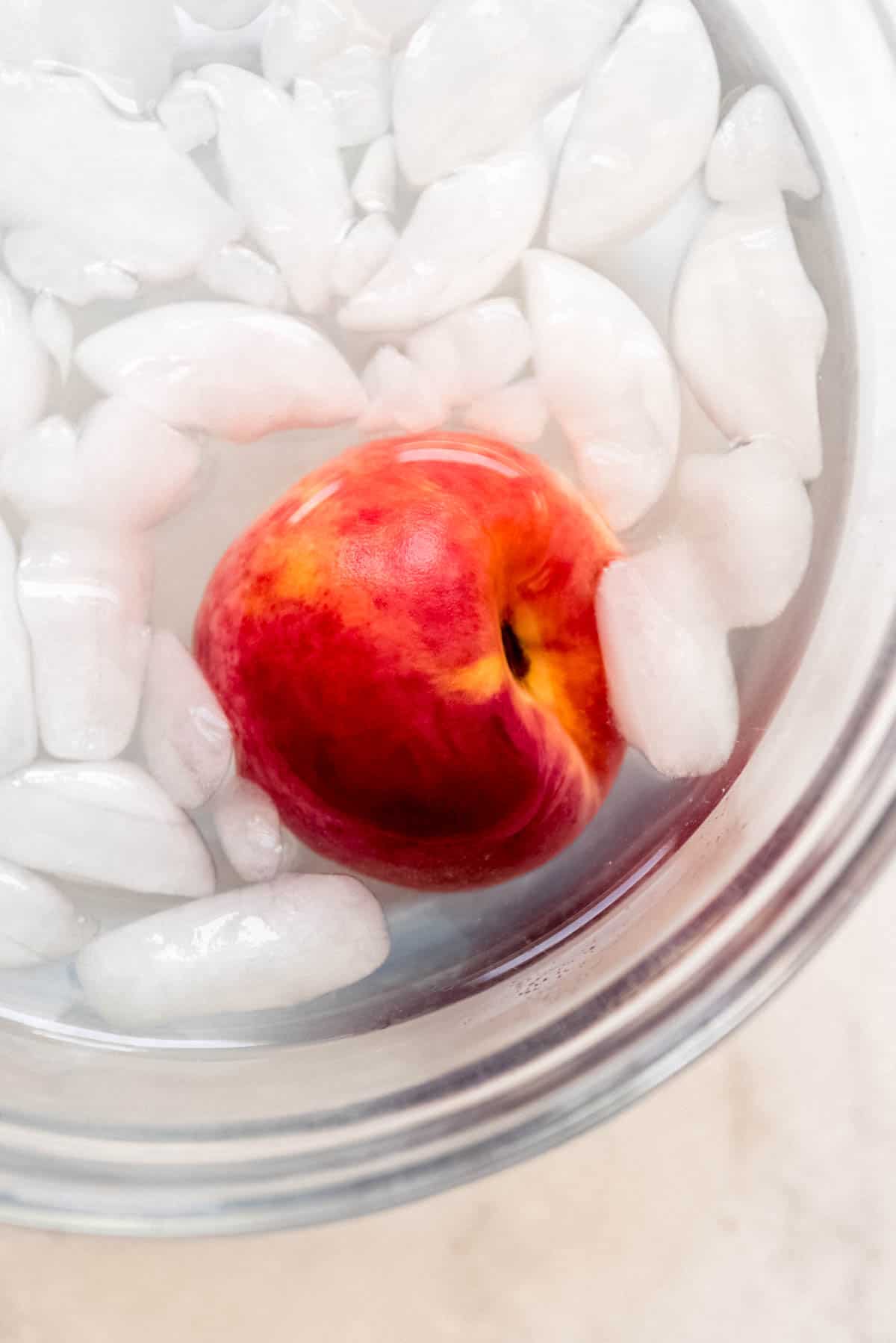 A peach in an ice water bath.