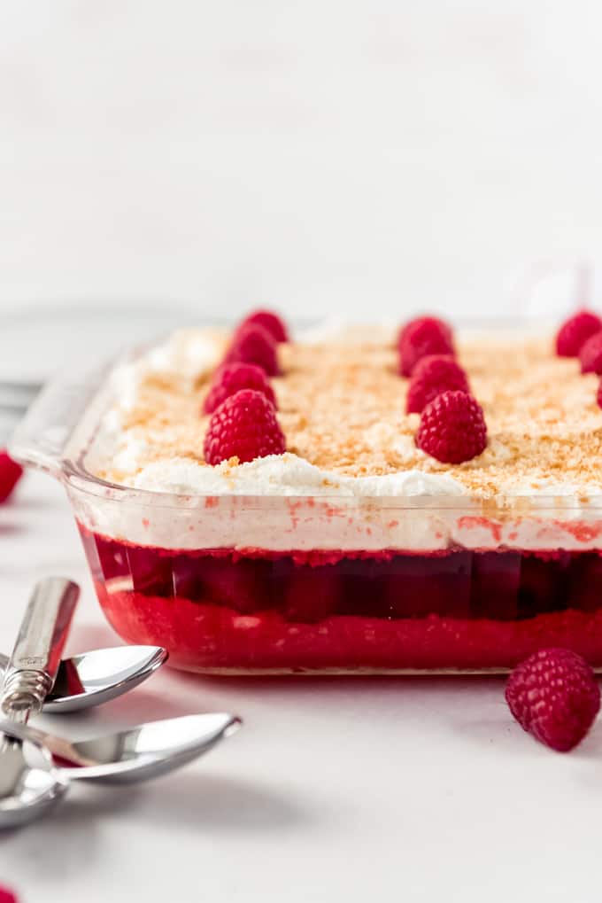 layers of raspberry jello, cookie crumbs, and whipped cream in a baking dish