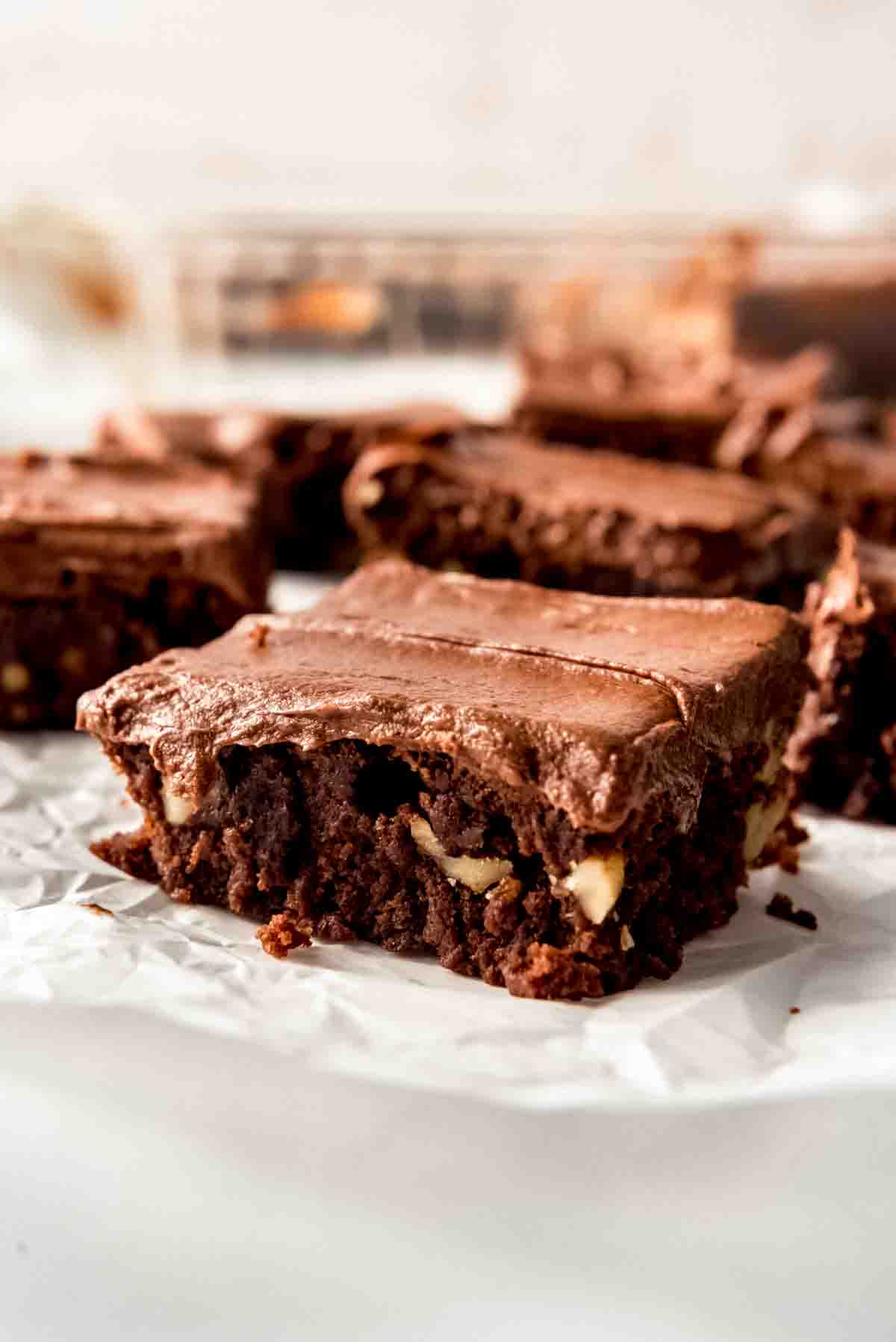 A frosted brownie with walnuts.