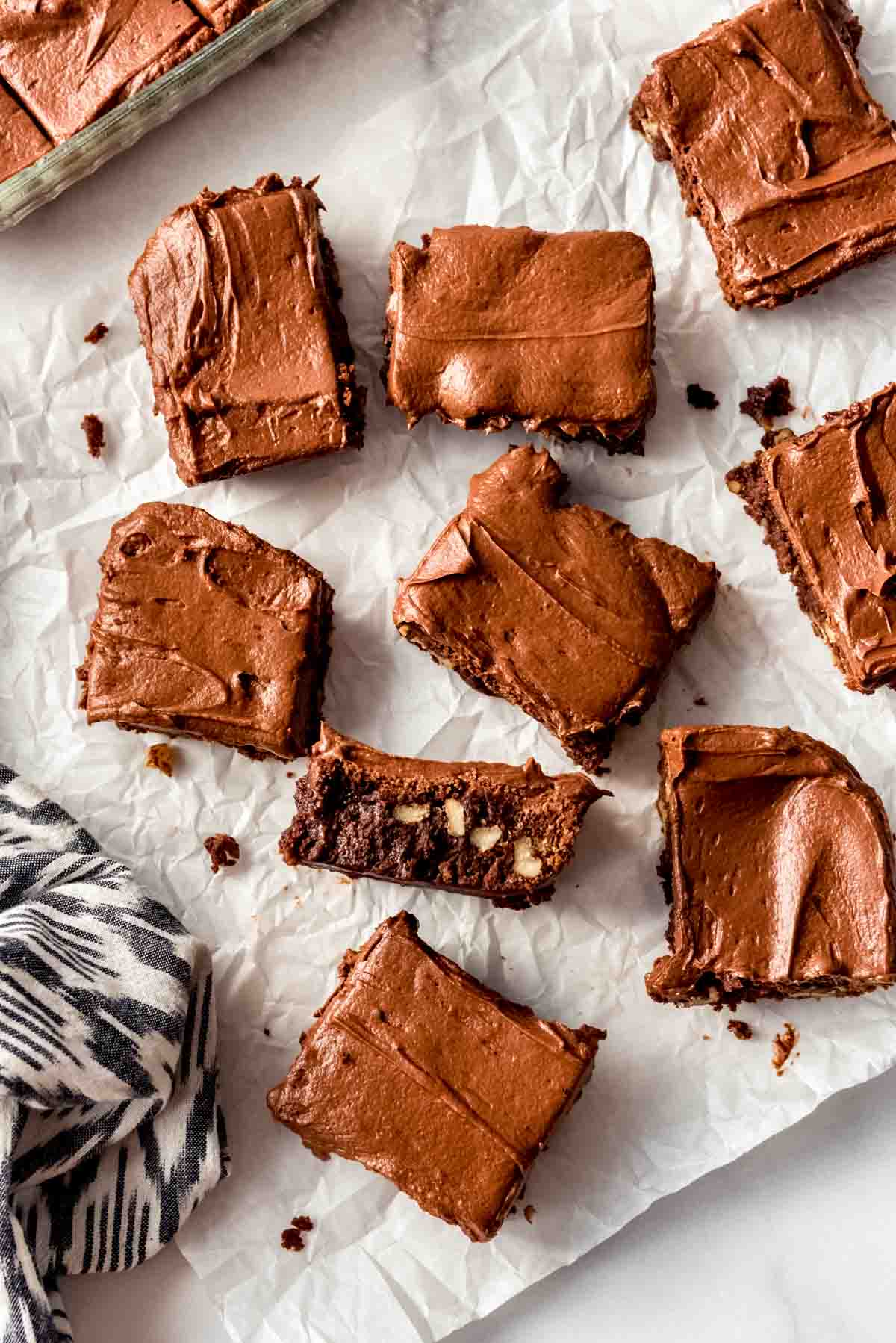 Frosted brownies on parchment paper.