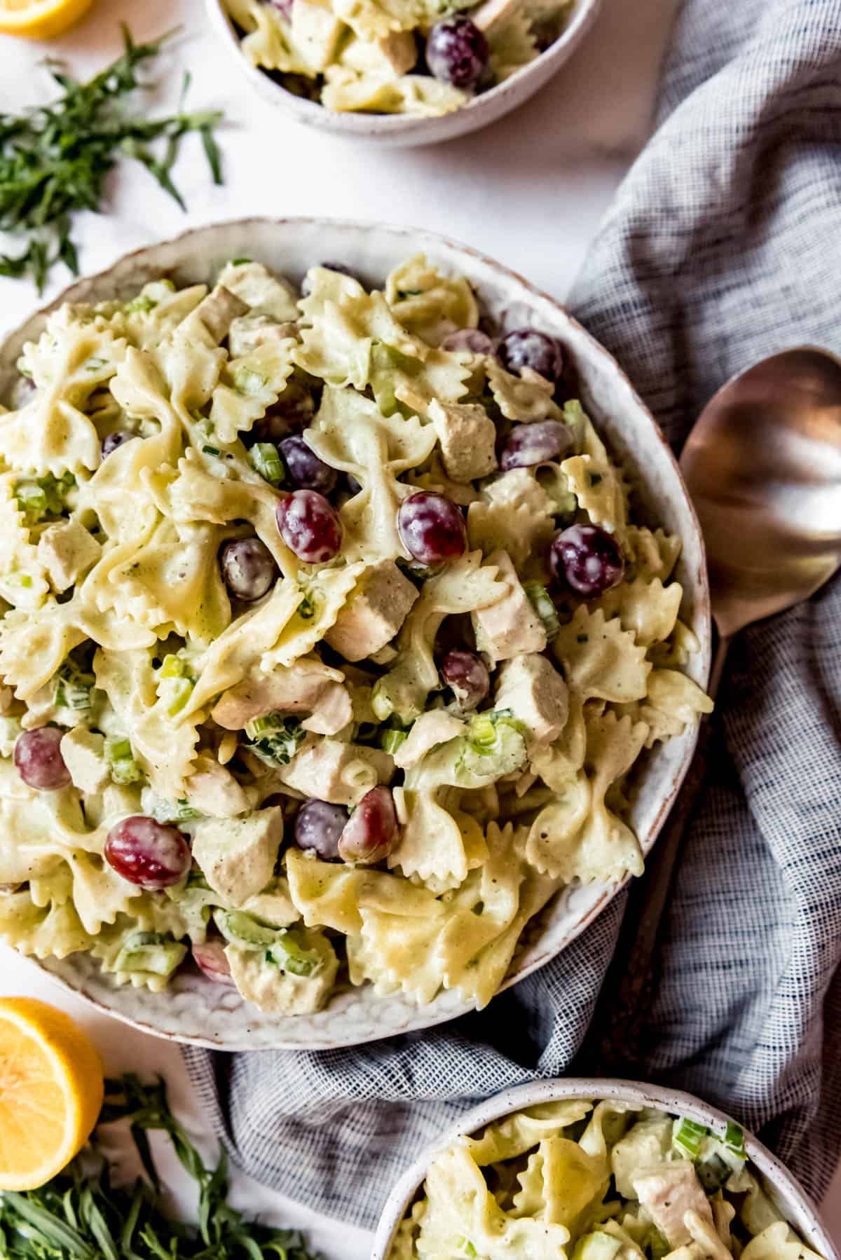 Overhead shot of Lemon Tarragon Pasta Salad, in stoneware bowl next to a spoon