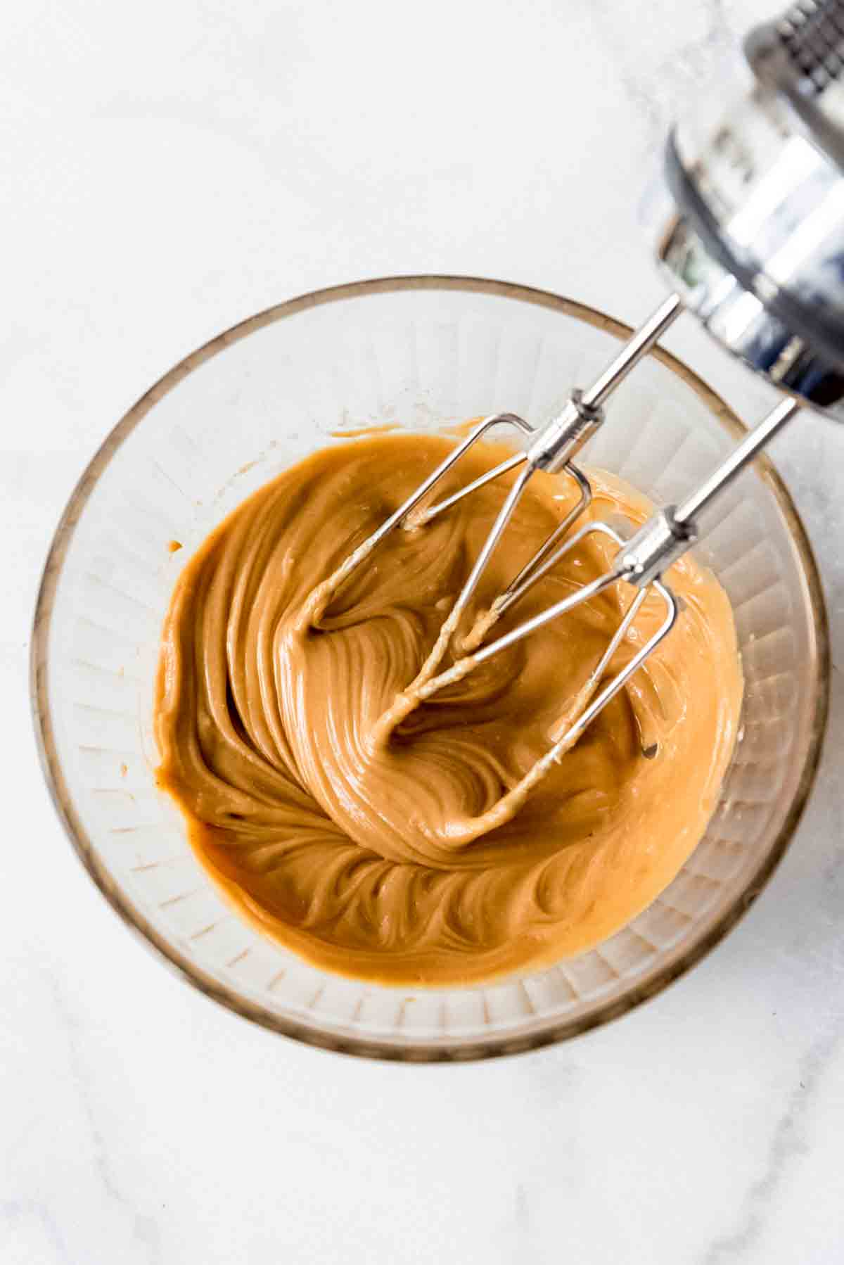 Peanut butter fudge in bowl with mixer.