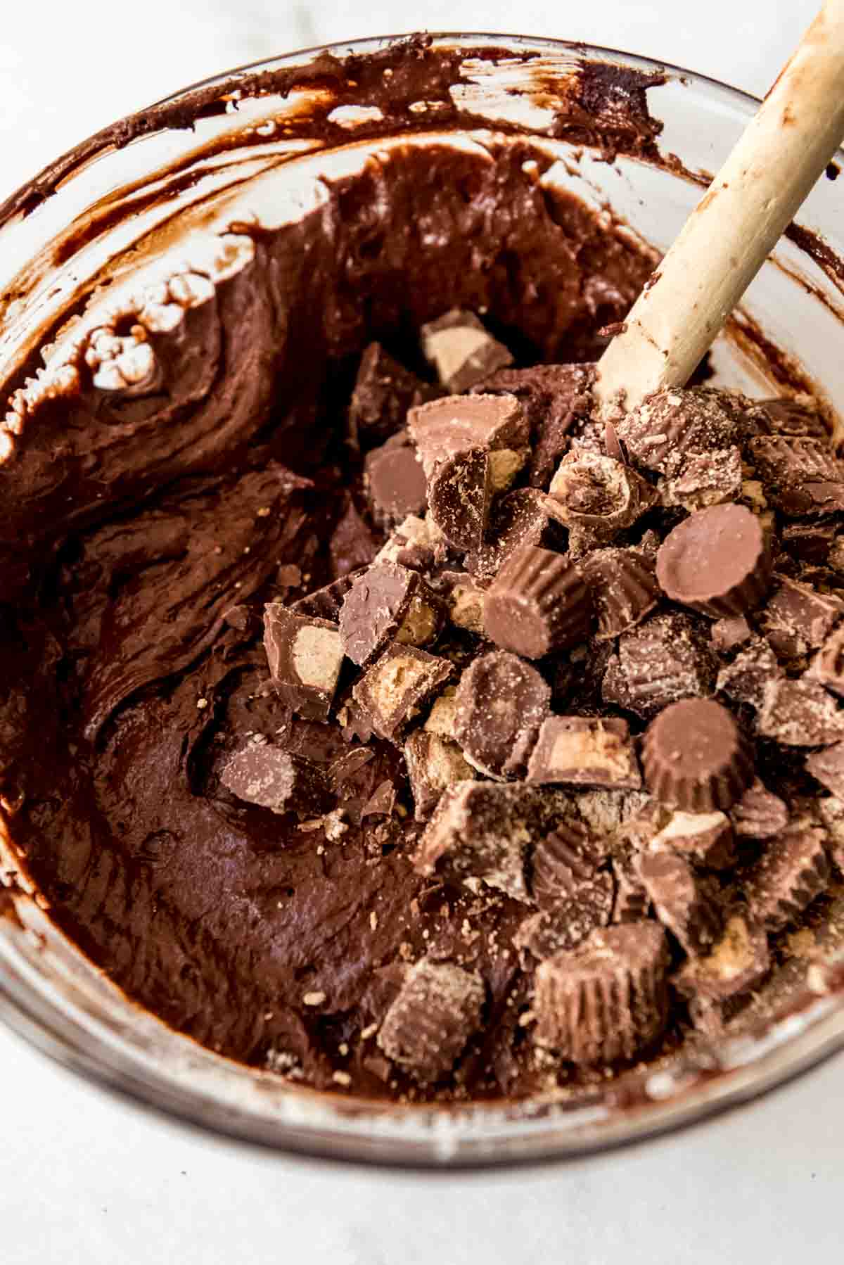 Adding chopped Reese's peanut butter cups to brownies batter.