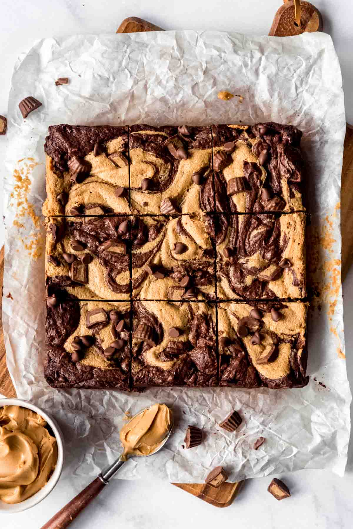 Square of Peanut Butter Swirl Brownies freshly cut on parchment paper, overhead shot.