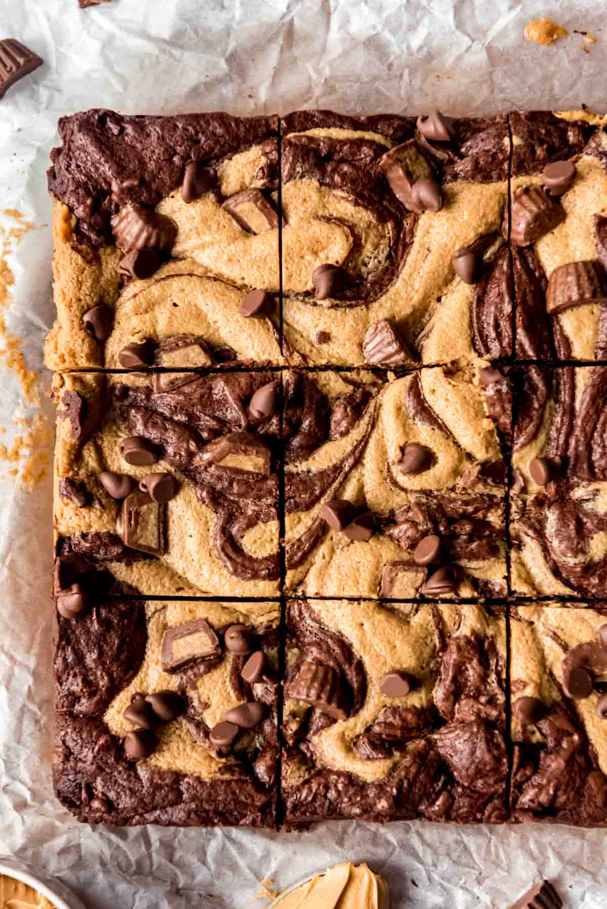 Square of Peanut Butter Swirl Brownies freshly cut on parchment paper, overhead shot off center