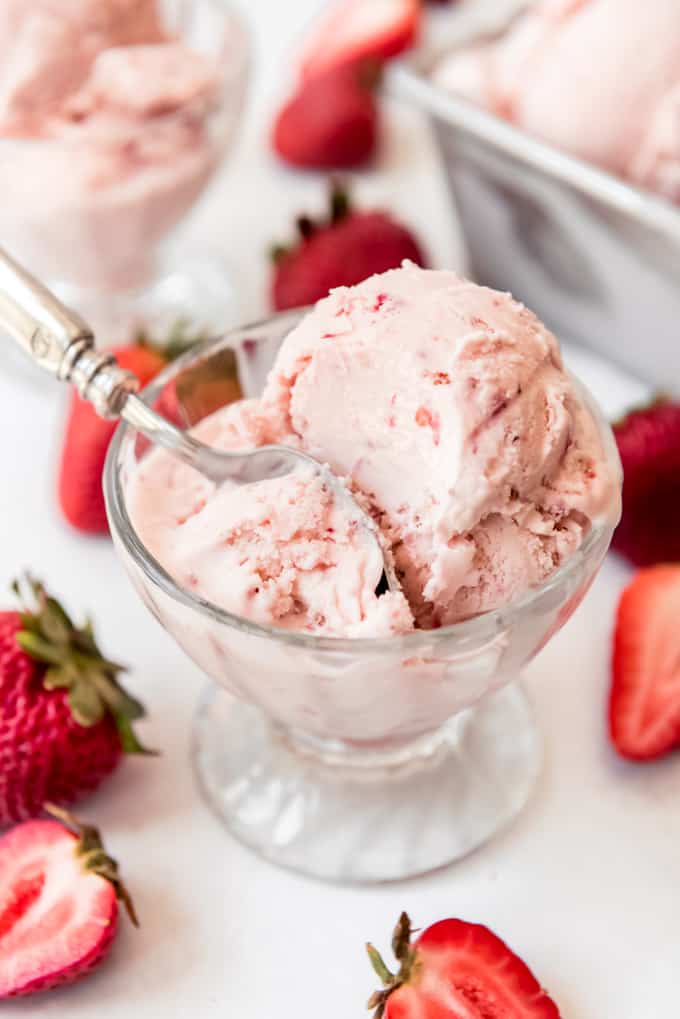 a scoop of homemade strawberry ice cream in a glass dish