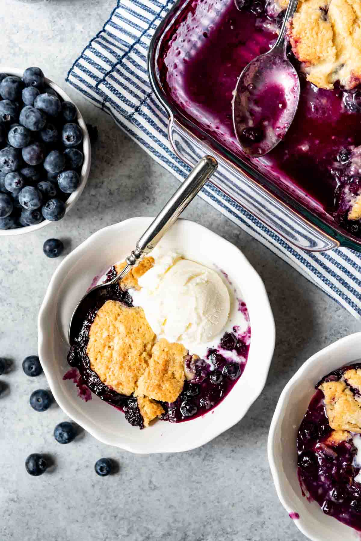 A scoop of blueberry cobbler with ice cream in a bowl.