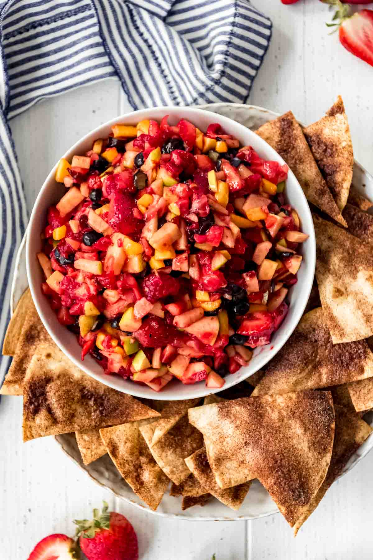 A bowl of fresh fruit salsa with cinnamon sugar tortilla chips on the side.