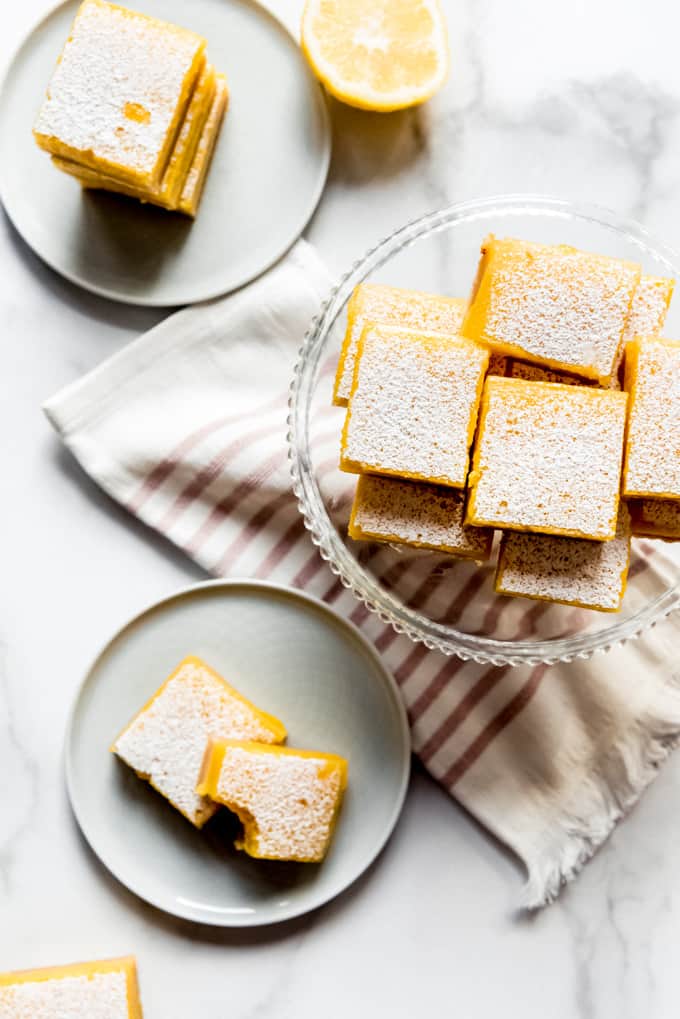 lemon squares stacked on plates and cake stands