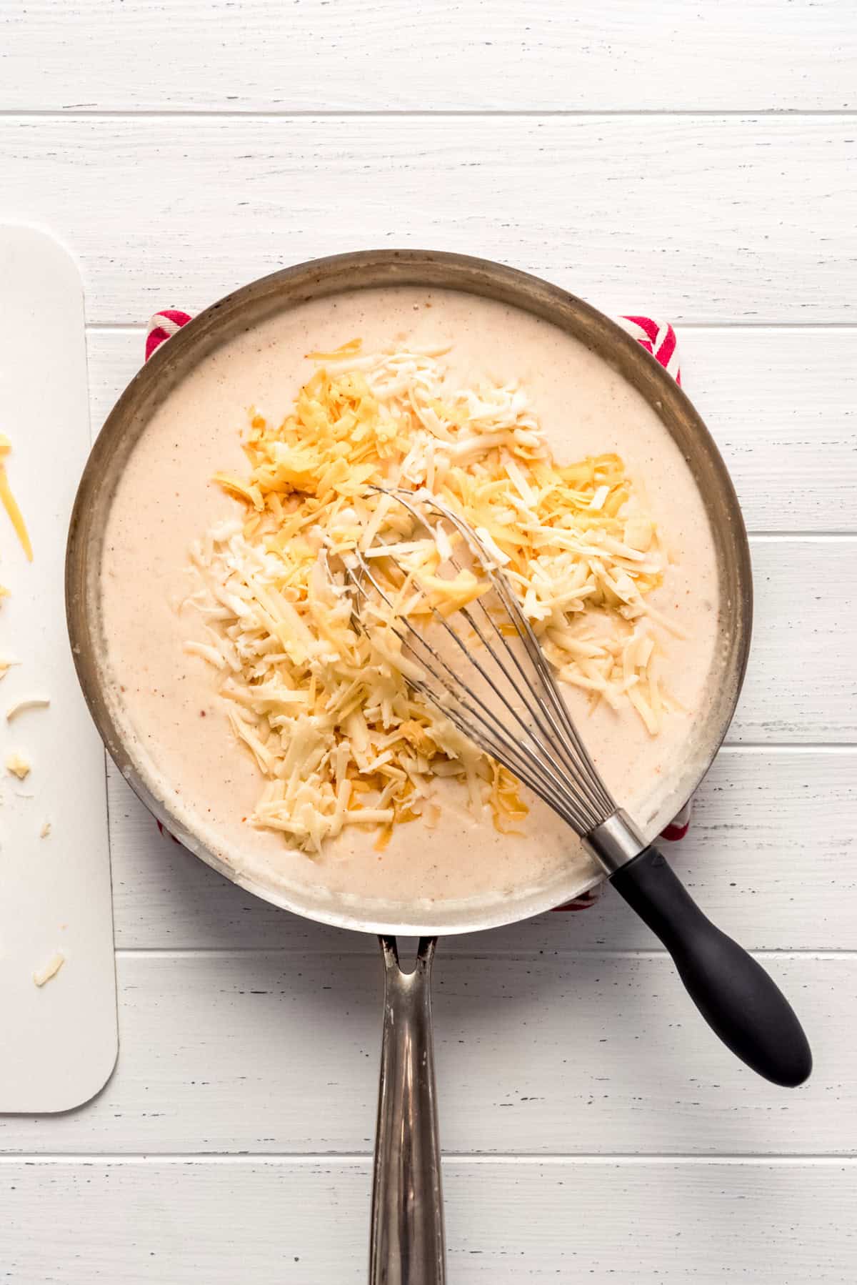 adding grated cheese to a homemade sauce