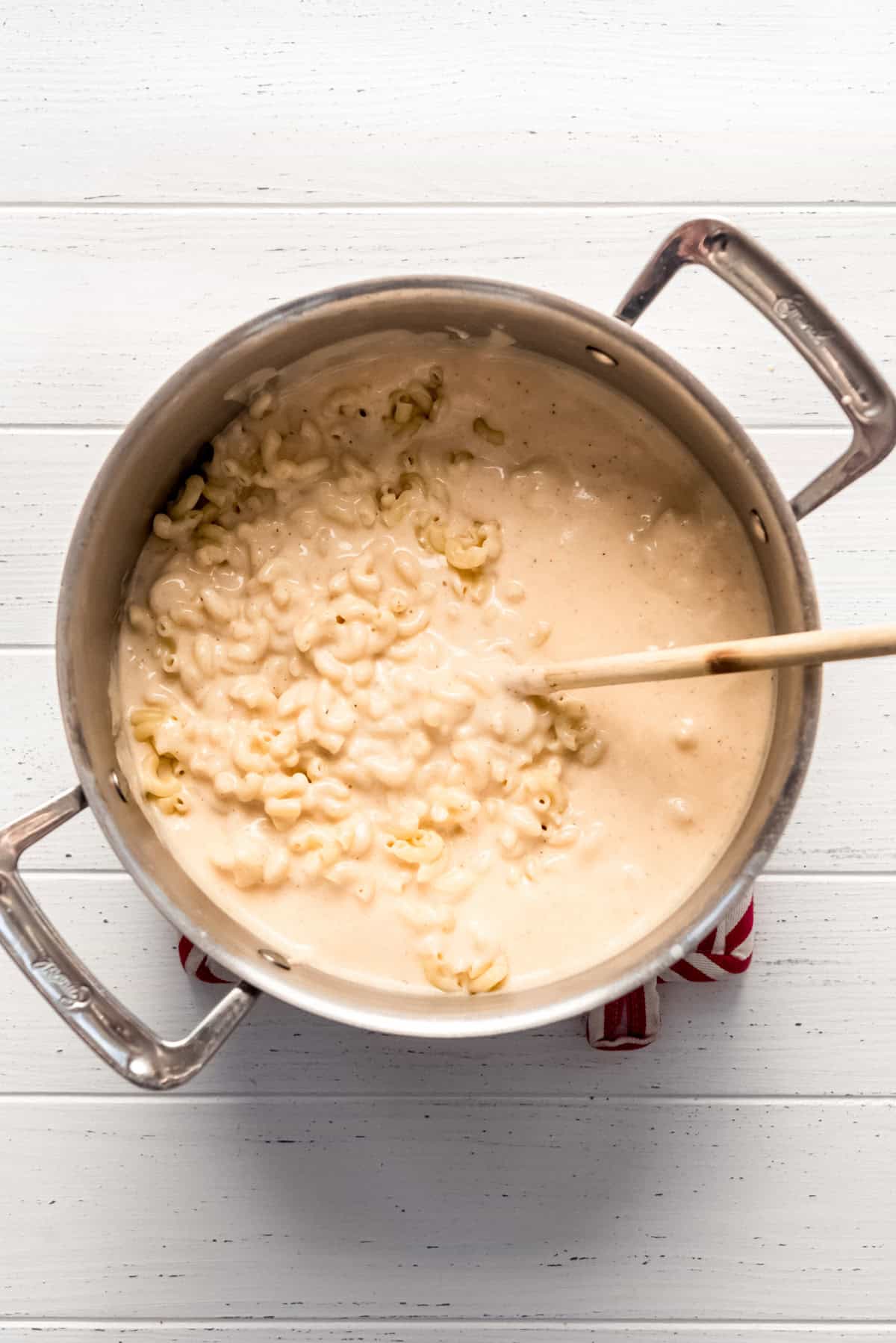 pouring sauce over cooked macaroni pasta