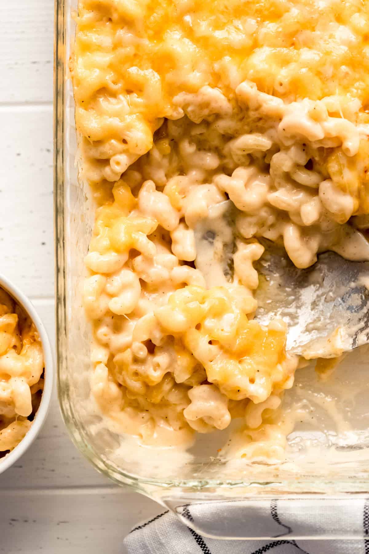 macaroni and cheese being scooped out of a casserole dish