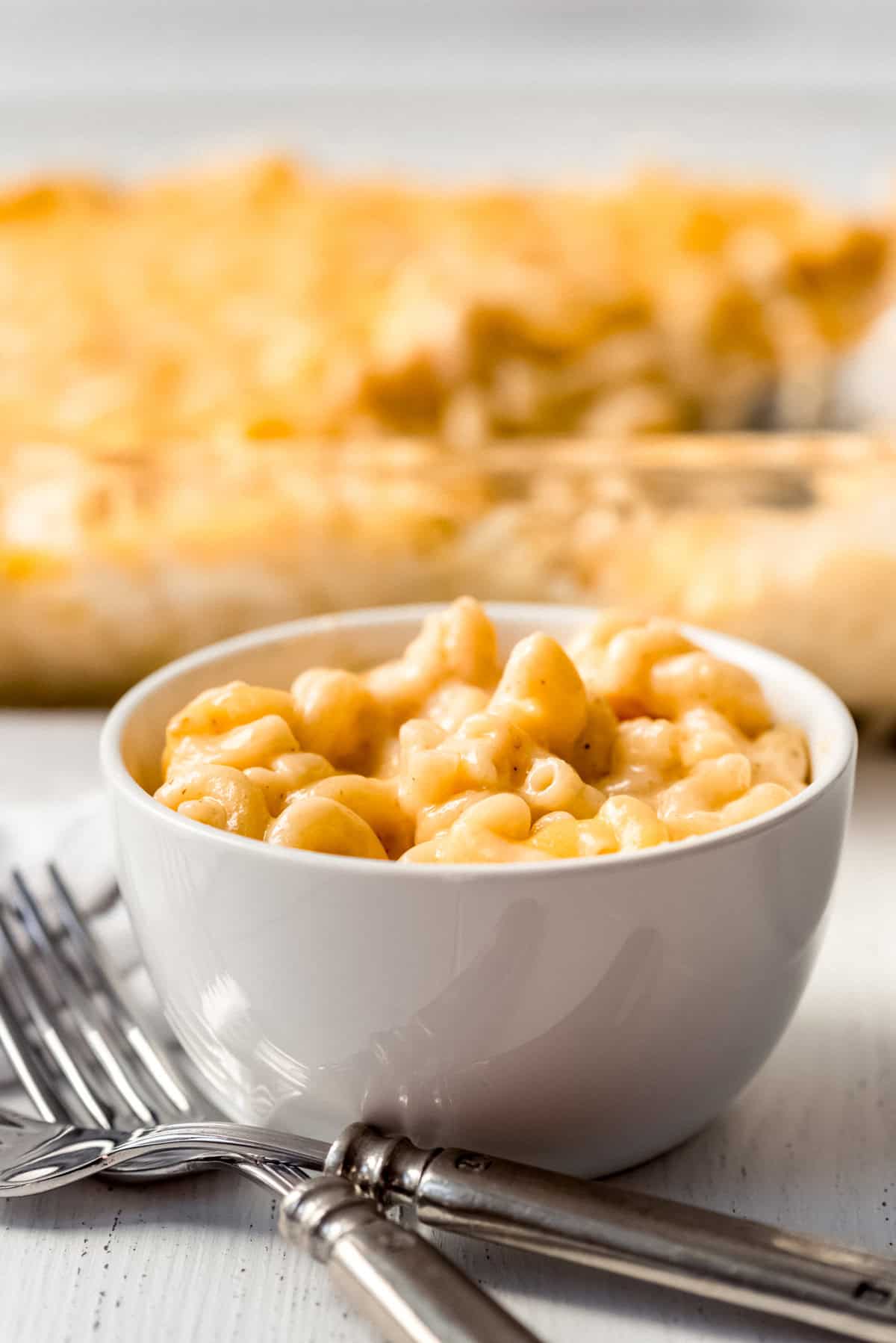 a bowl of homemade mac and cheese in front of a casserole dish