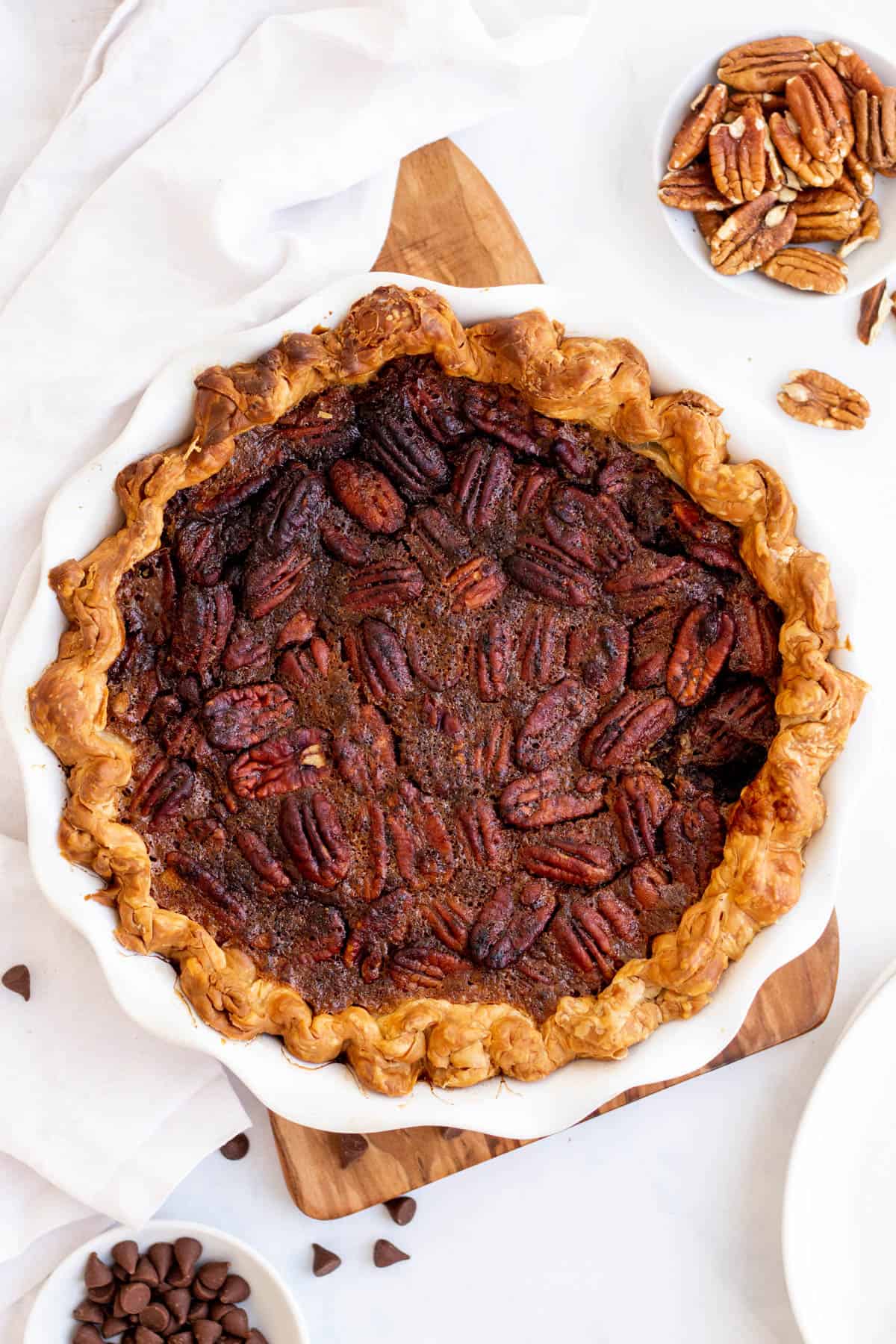 a whole chocolate pecan pie in a white pie dish