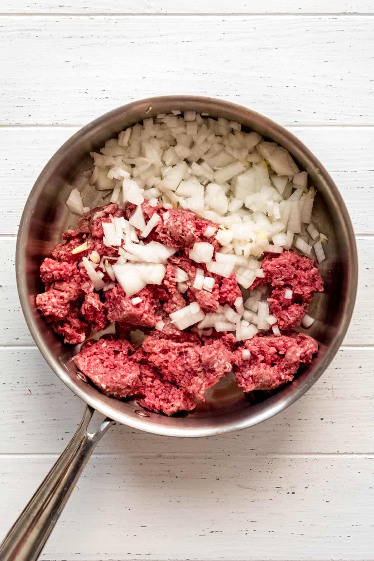 Ground beef and diced onions in a large skillet. 