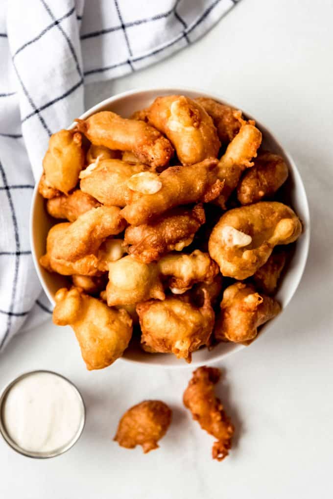 fried cheese curds piled up in a white bowl