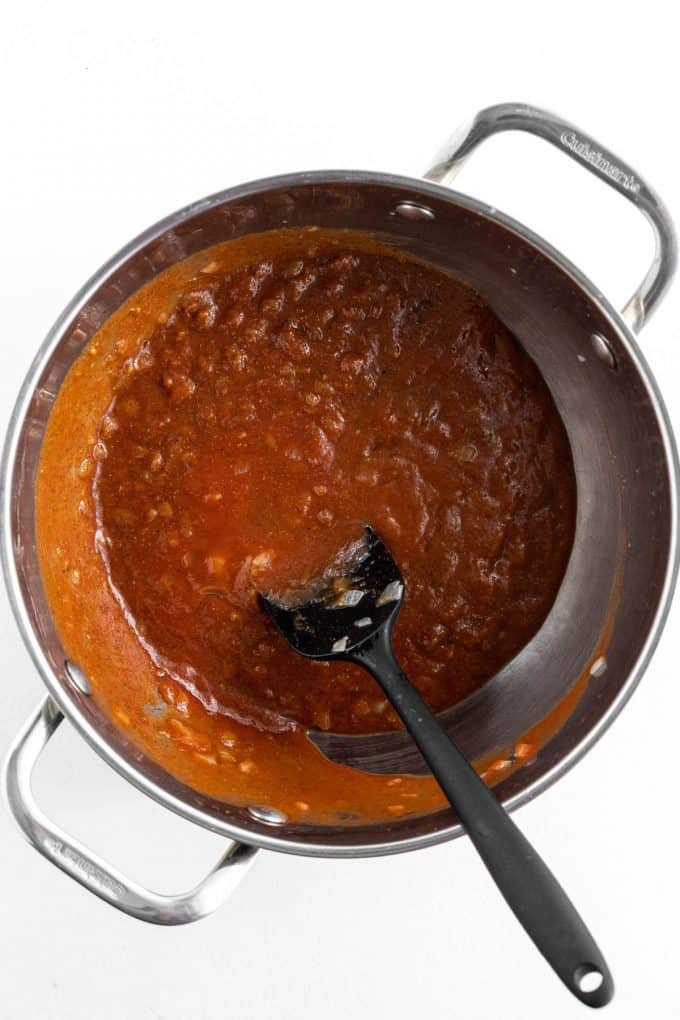 Simmering a rich spiced tomato broth in a large pot.