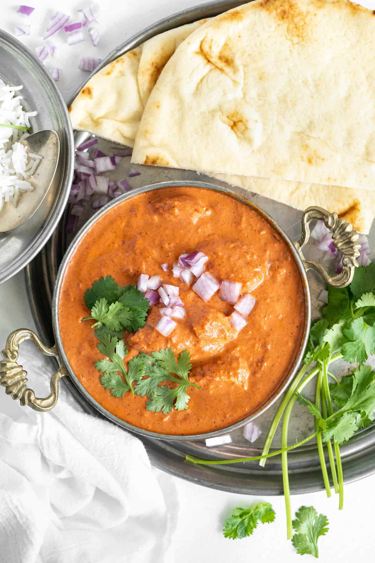 Butter Chicken served with naan bread and rice.