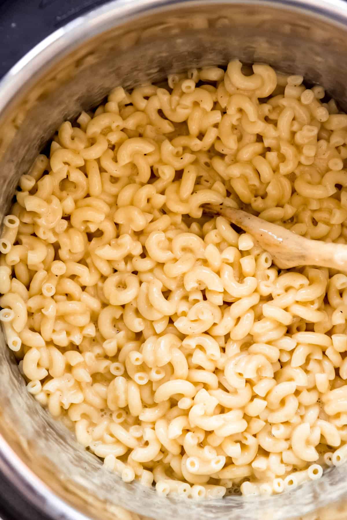 a close image of a spoon stirring homemade macaroni and cheeese