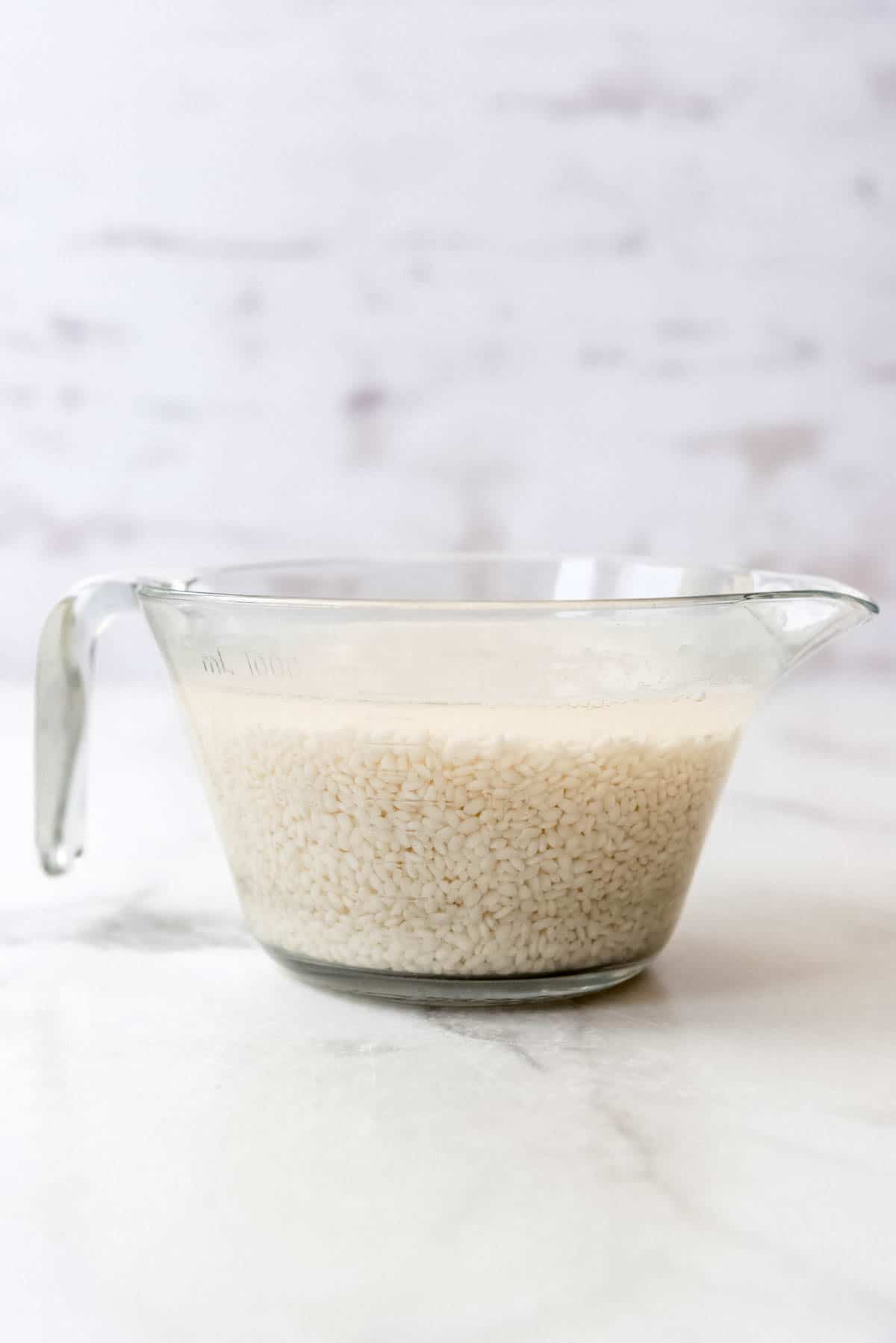Close up of large glass mixing jug with rice in it.