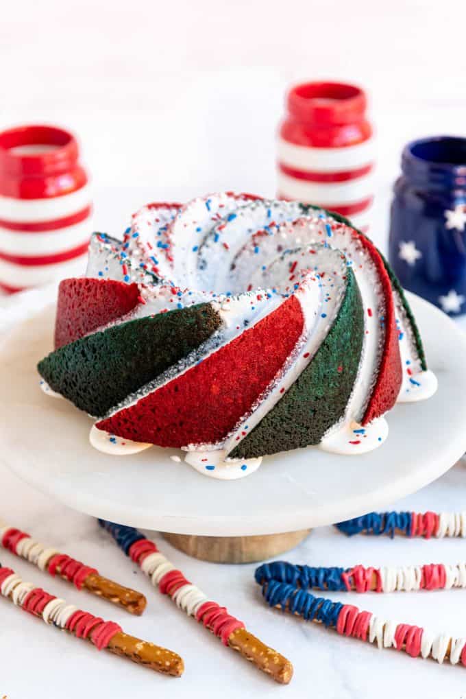 a patriotic bundt cake with sprinkles on a cake stand
