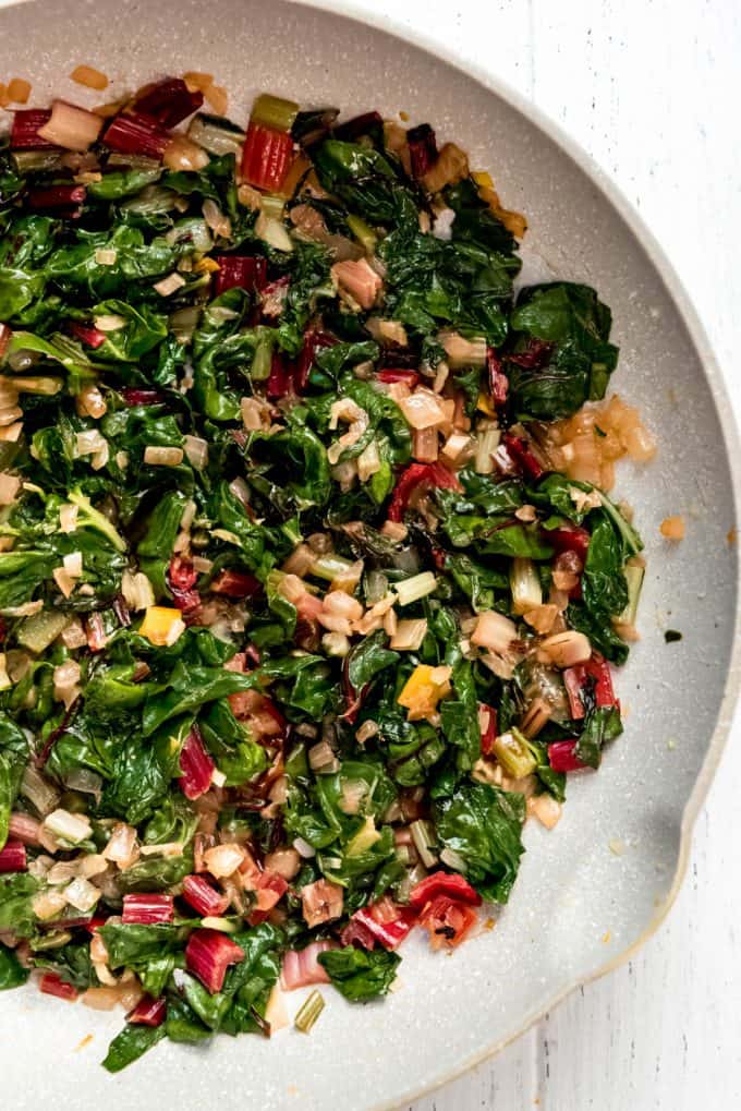 chopped and sauteed rainbow chard and onions in a pan
