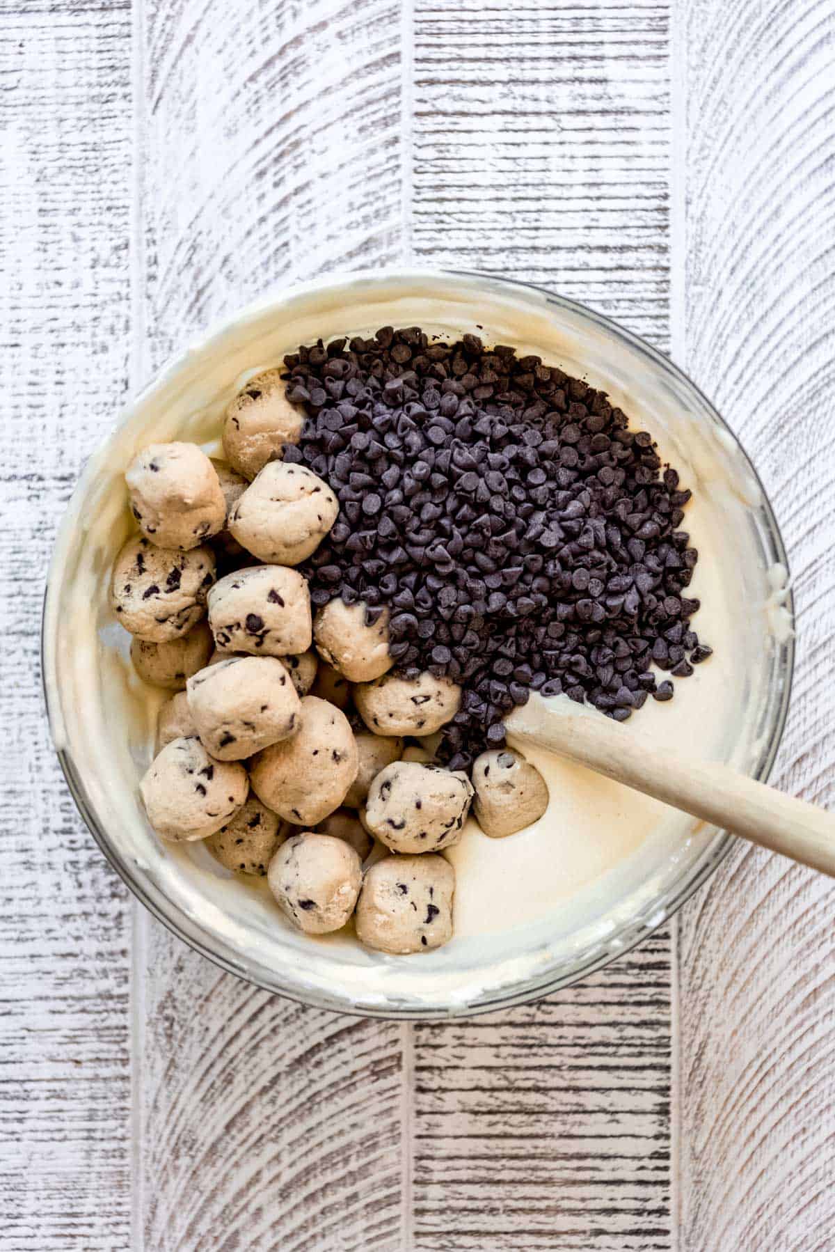 Cookie dough balls and mini chocolate chips are mixed with some cheesecake dough. 