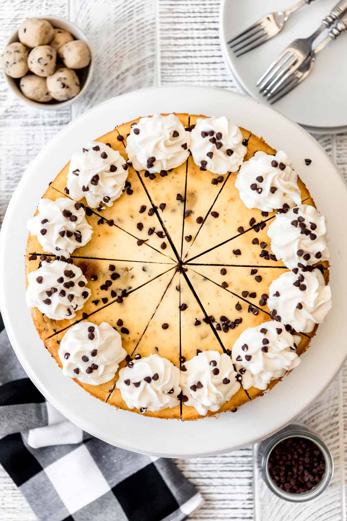 an overhead image of cheesecake decorated with whipped cream and mini chocolate chips