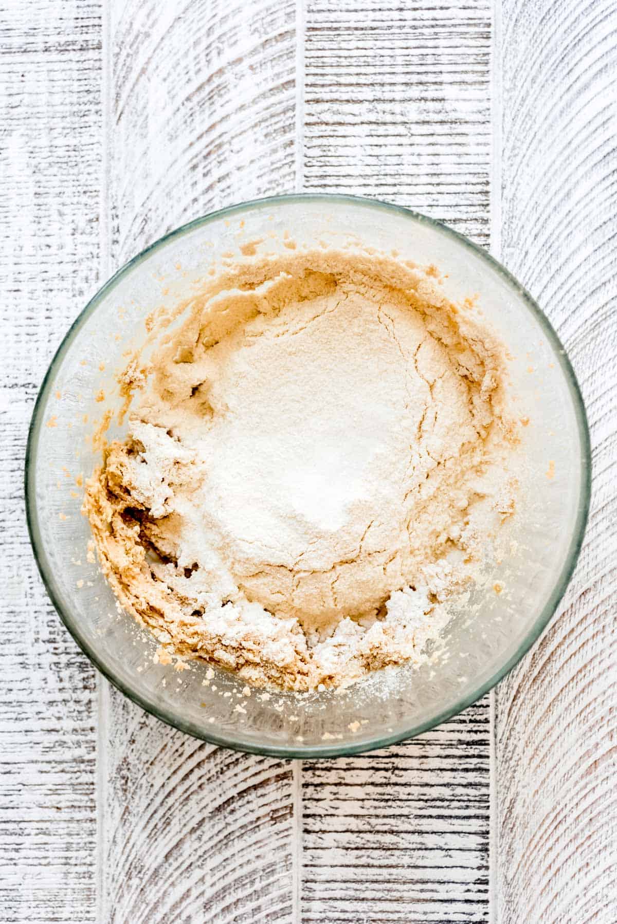 Adding heat-treated flour and salt to cookie dough batter. 