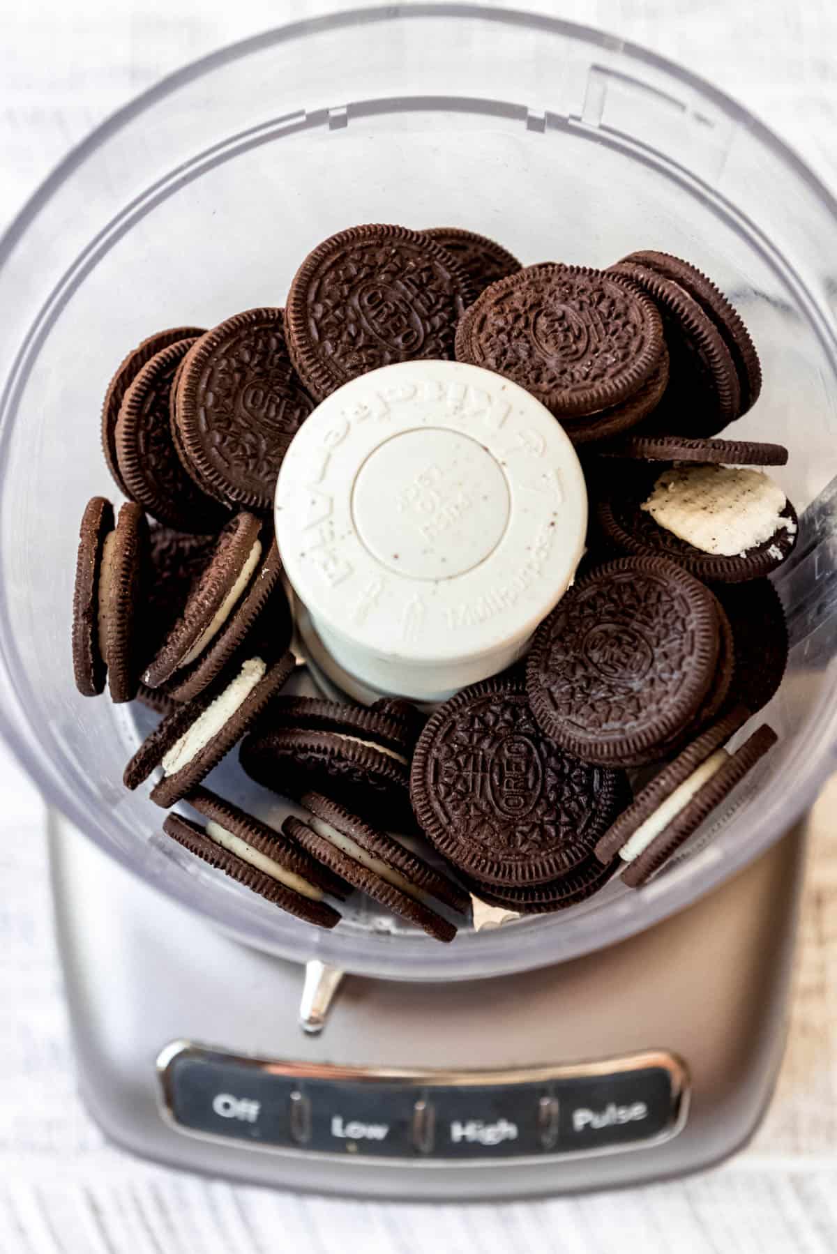 Oreos are in a food processor, ready to be blended. 